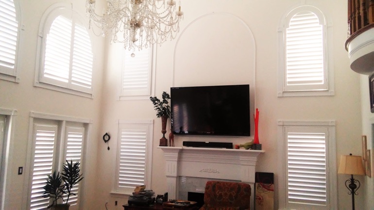 Honolulu great room with wall-mounted TV and arc windows.